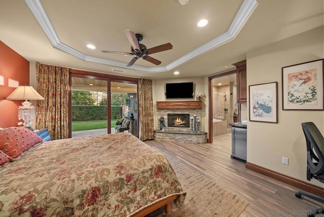 bedroom featuring a tray ceiling, ceiling fan, ornamental molding, and access to outside