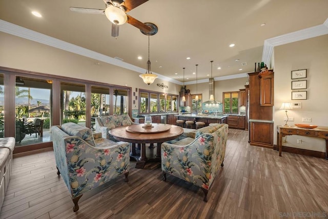 living room featuring hardwood / wood-style floors, ceiling fan, and ornamental molding