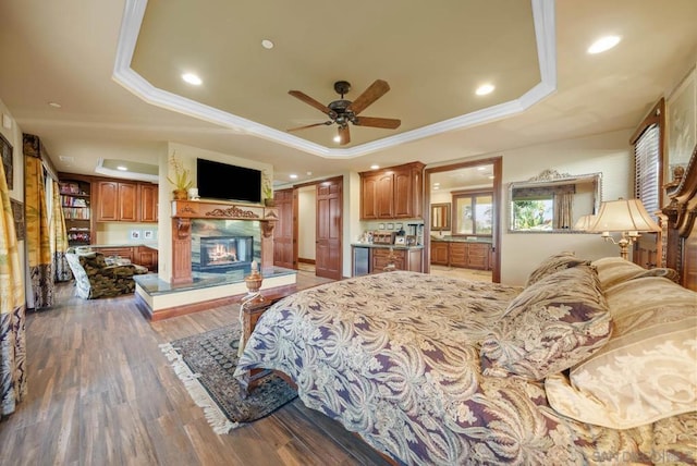 bedroom featuring ceiling fan, a raised ceiling, wood-type flooring, and crown molding