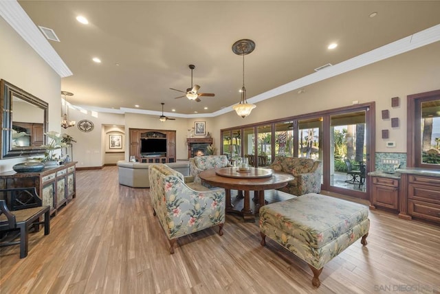 living room with light wood-type flooring, ceiling fan, and ornamental molding