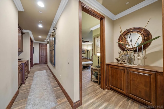 hall with light hardwood / wood-style flooring and ornamental molding