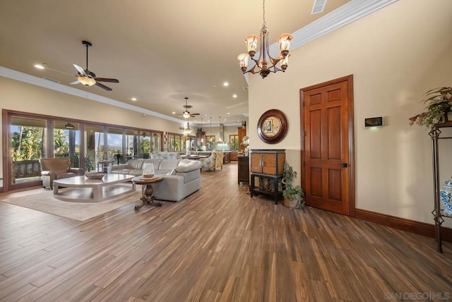 living room with ceiling fan with notable chandelier, wood-type flooring, and crown molding