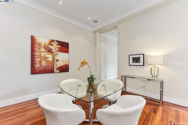 dining space with wood-type flooring and ornamental molding