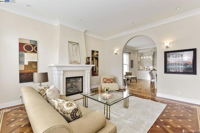 living room with parquet flooring, a large fireplace, and ornamental molding