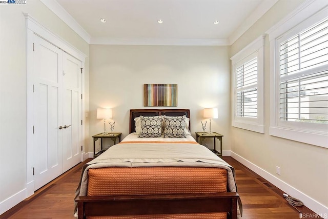 bedroom with a closet, dark hardwood / wood-style flooring, and ornamental molding