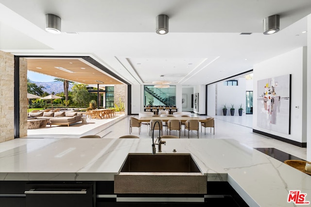 kitchen featuring light stone counters and sink