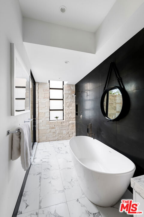 bathroom with tile walls and a bathing tub