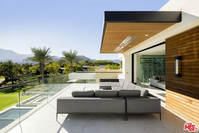 view of patio / terrace with outdoor lounge area, a mountain view, and a balcony