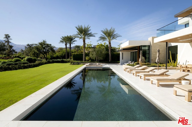 view of pool with a patio area and a lawn