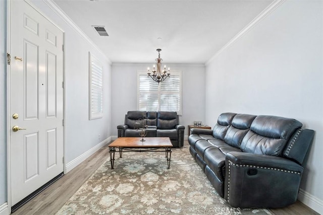 living room featuring ornamental molding, a notable chandelier, and hardwood / wood-style flooring