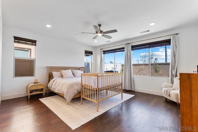 bedroom featuring multiple windows, ceiling fan, and dark wood-type flooring