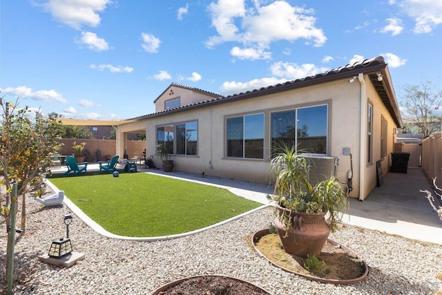 back of house with a lawn, a patio area, and central AC