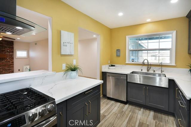 8121 San Mateo Cir, Buena Park, CA 90620 - kitchen featuring stainless steel appliances, a sink, recessed lighting, light wood-style floors, and light stone countertops
