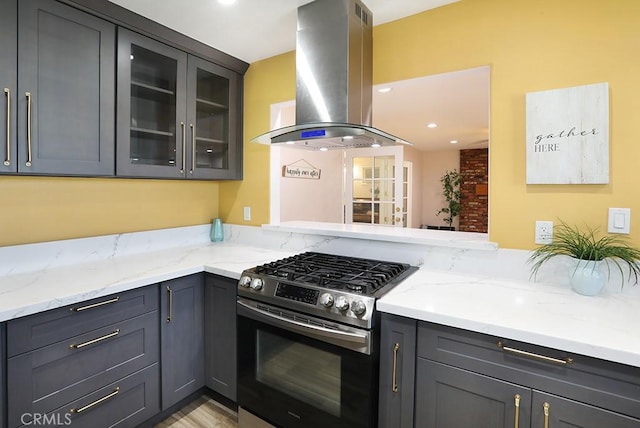 8121 San Mateo Cir, Buena Park, CA 90620 - kitchen featuring exhaust hood, light hardwood / wood-style floors, light stone counters, kitchen peninsula, and stainless steel range with gas stovetop