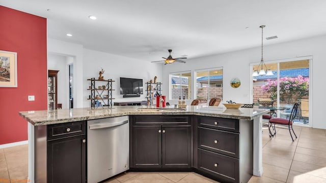 kitchen with hanging light fixtures, a center island with sink, light tile patterned floors, and stainless steel dishwasher