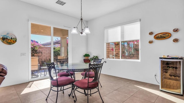 tiled dining room with a chandelier