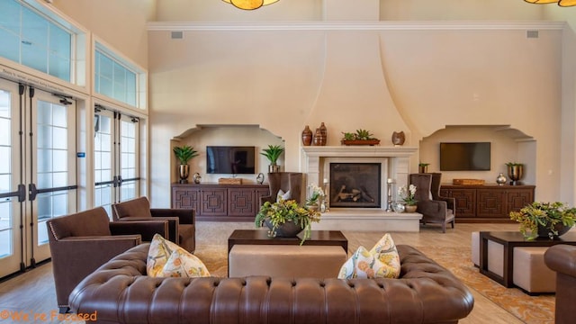 interior space featuring crown molding, a large fireplace, and a towering ceiling