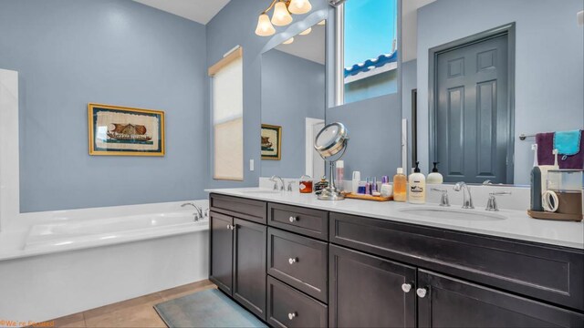 bathroom featuring a bathing tub, tile patterned flooring, and vanity