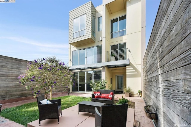 rear view of house with outdoor lounge area and a patio