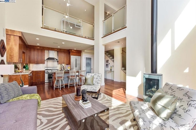 living room with dark wood-type flooring and a high ceiling