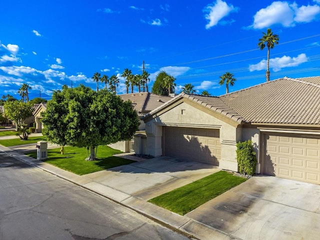 ranch-style house featuring a front lawn and a garage