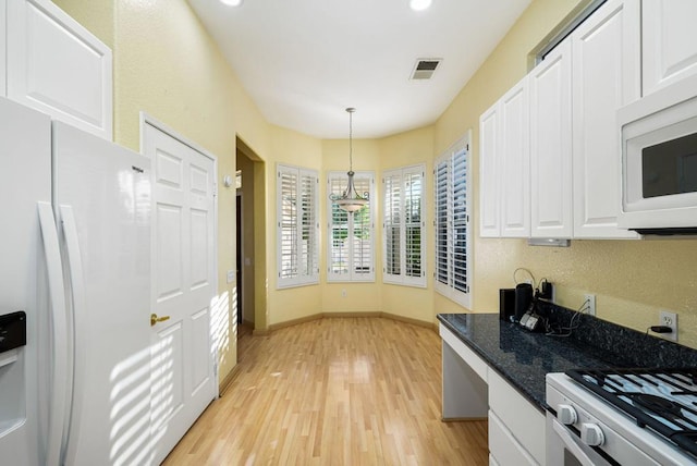 kitchen with white cabinetry, light hardwood / wood-style flooring, decorative light fixtures, and white appliances