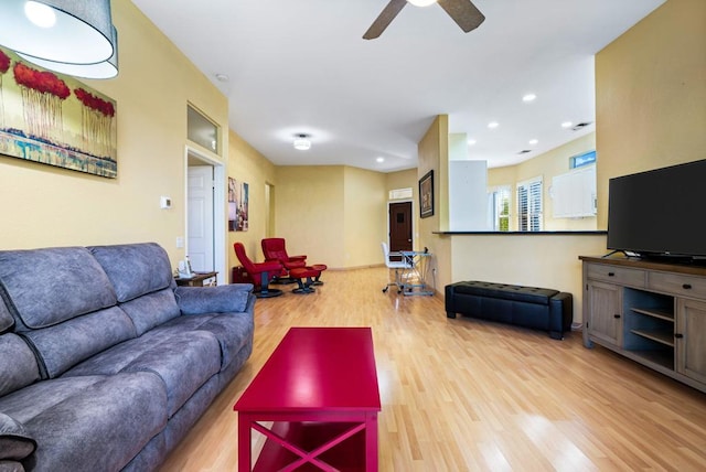 living room with ceiling fan and light hardwood / wood-style flooring