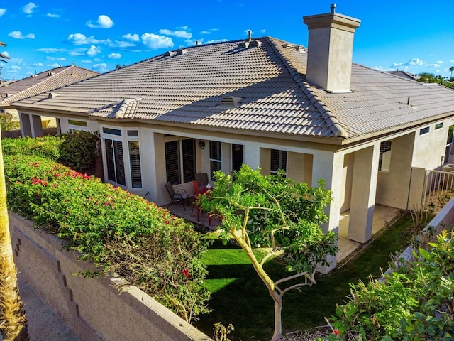 rear view of property featuring a yard and a patio area