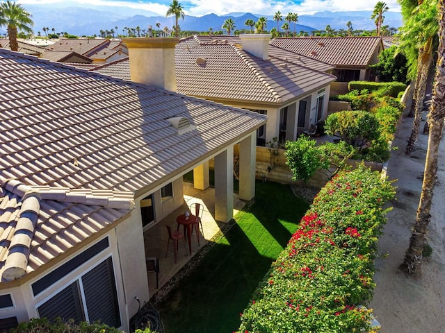 exterior space with a mountain view, a patio area, and a yard