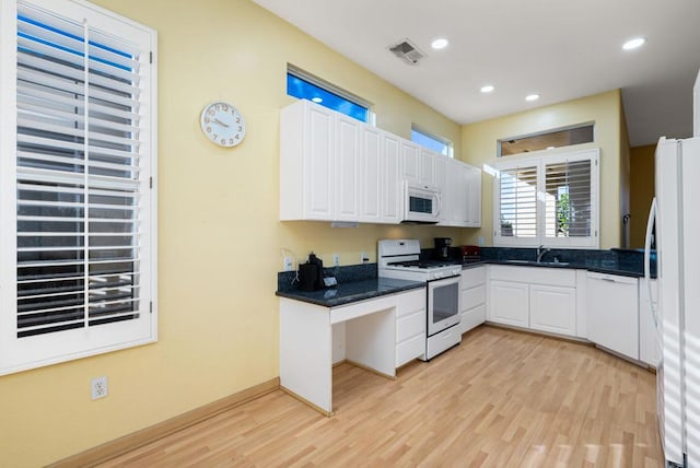 kitchen featuring white cabinets, white appliances, light hardwood / wood-style floors, and sink