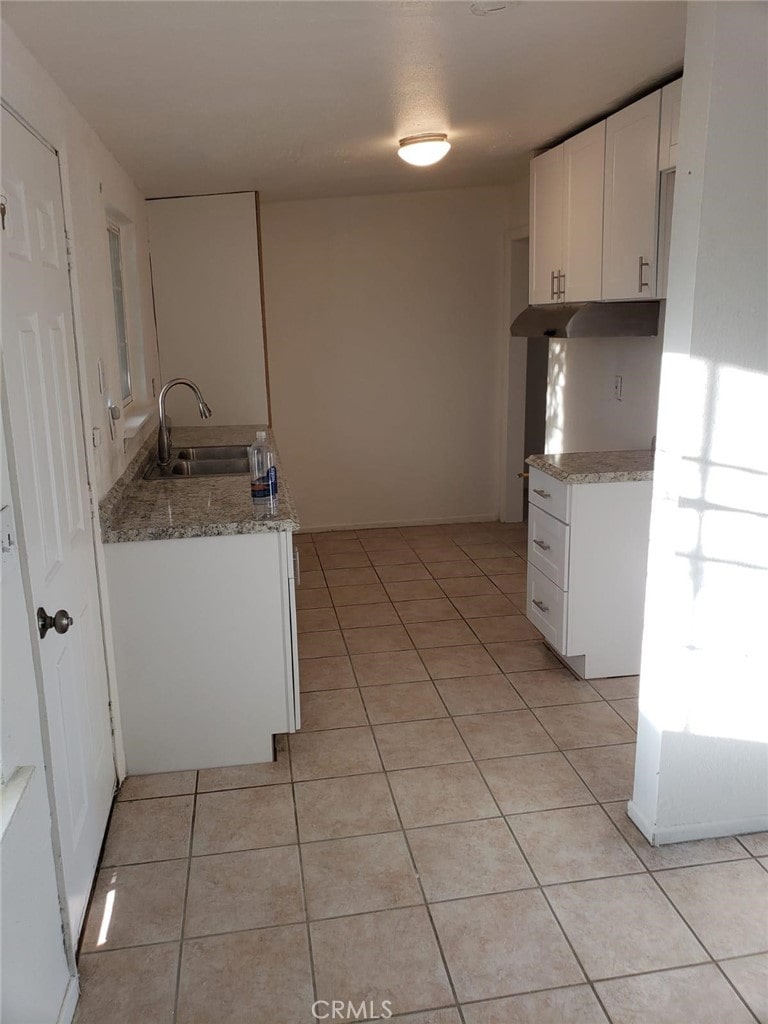 13345 Mesquite Rd Unit 2, Whitewater, CA 92282 - kitchen with light stone countertops, white cabinetry, sink, and light tile patterned floors