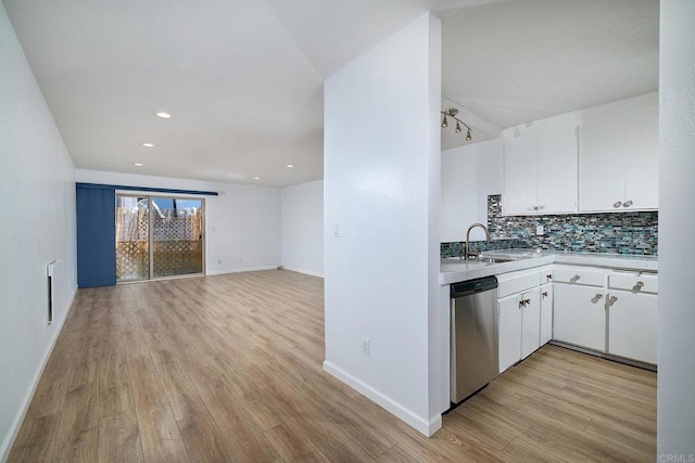 kitchen featuring tasteful backsplash, stainless steel dishwasher, sink, light hardwood / wood-style flooring, and white cabinetry