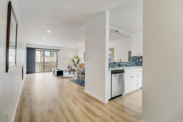 hall featuring light wood-type flooring, rail lighting, and sink