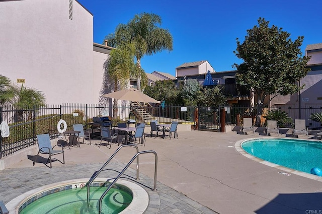 view of swimming pool featuring a patio and a hot tub