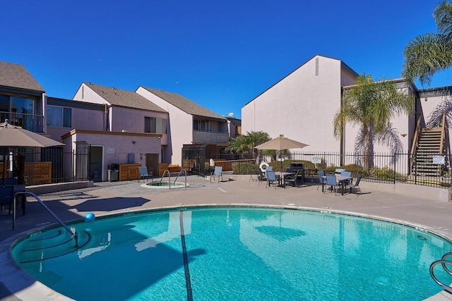 view of swimming pool with a patio and a hot tub