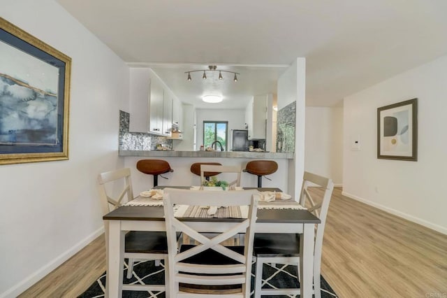 dining area with light hardwood / wood-style floors and sink