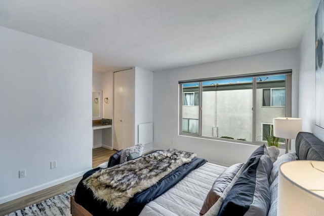 bedroom with wood-type flooring and ensuite bath