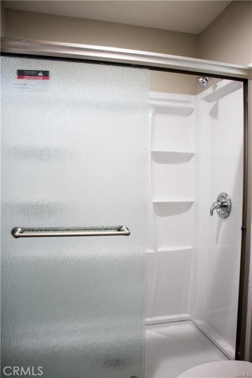 bathroom with a shower with door