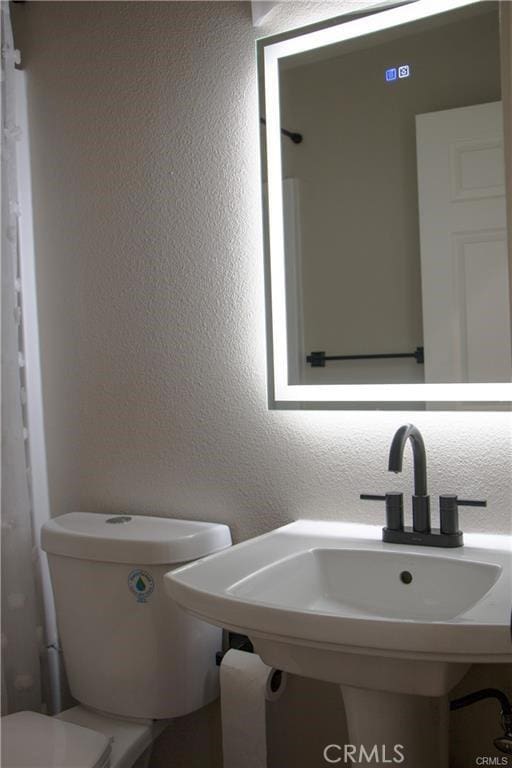 bathroom featuring toilet and sink