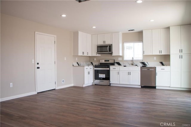 kitchen featuring dark hardwood / wood-style flooring, stainless steel appliances, and white cabinetry