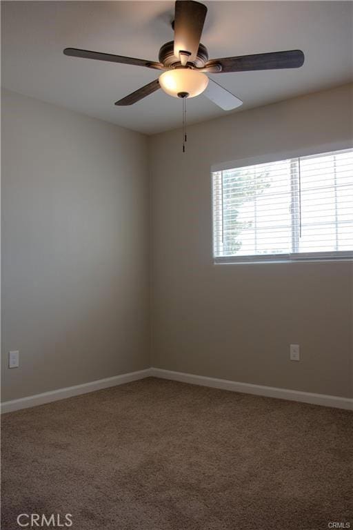 carpeted spare room featuring ceiling fan