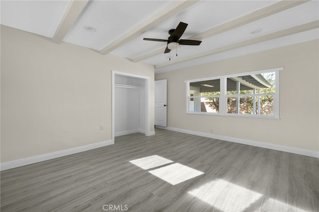 unfurnished bedroom featuring ceiling fan, a closet, beamed ceiling, and light hardwood / wood-style floors