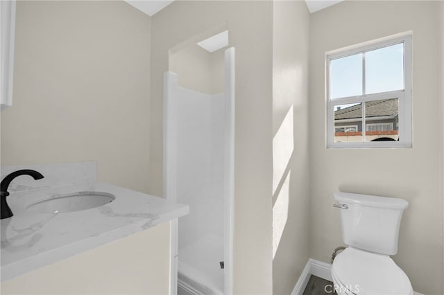 bathroom with vanity, toilet, and walk in shower