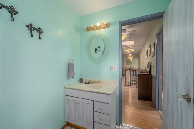 bathroom with hardwood / wood-style flooring, ceiling fan, and vanity