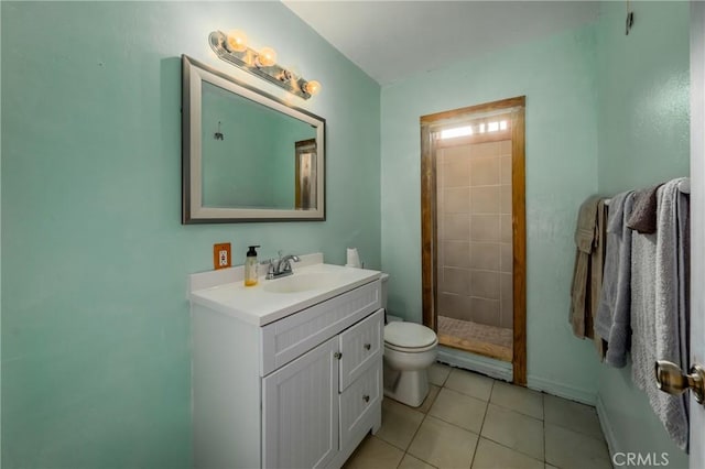 bathroom featuring tiled shower, vanity, tile patterned flooring, and toilet