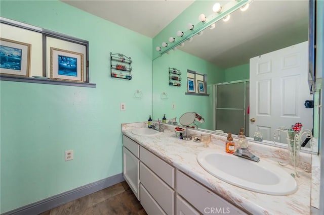 bathroom with vanity, a shower with door, and wood-type flooring