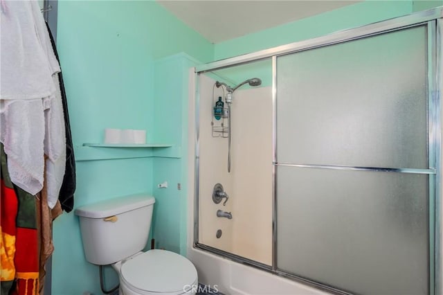 bathroom with bath / shower combo with glass door and toilet