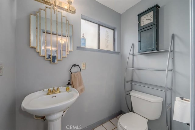 bathroom featuring sink, toilet, and tile patterned flooring