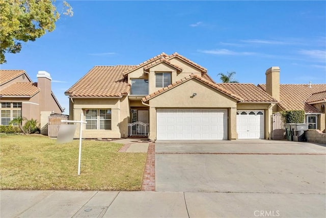 mediterranean / spanish house with a garage and a front yard