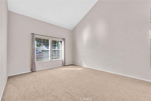 carpeted spare room featuring lofted ceiling